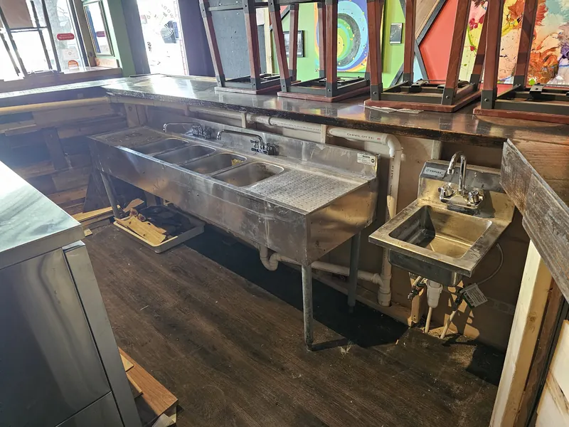 Bar three-compartment sink and hand sink plumbed under a commercial bar