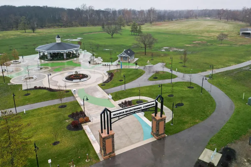 Aerial view of Bicentennial Commons park in Monroe with a gazebo, walking paths and green lawns