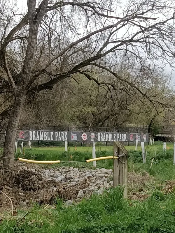 Bramble Park banner on a fence behind bare trees in Terrace Park