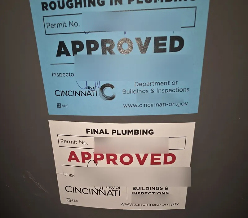 City of Cincinnati rough-in and final plumbing inspection stickers marked approved