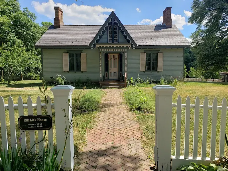 Elk Lick House, a small historic cottage behind a white picket fence in Sharonville