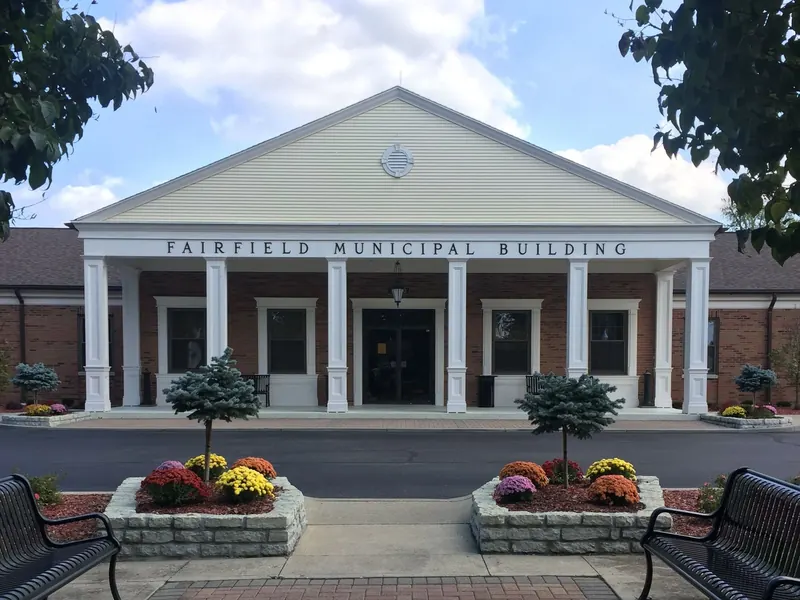 Fairfield Municipal Building with white columns, flower planters and benches out front