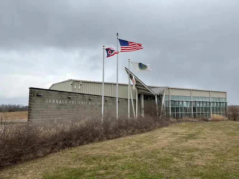 Fernald Preserve Visitors Center near Harrison with three flags on a cloudy day