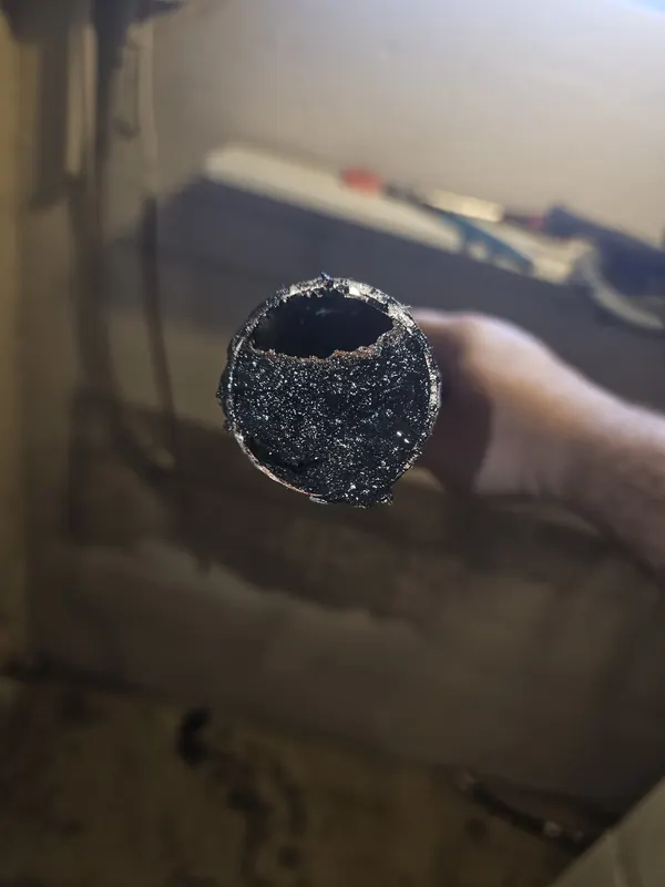 Cross-section of an old galvanized pipe nearly closed off by mineral buildup