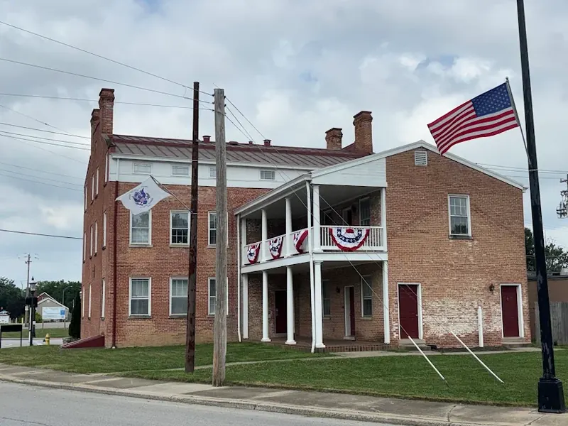 Historic red brick building with a two-story porch and an American flag in Sharonville