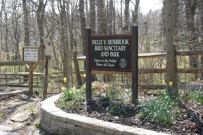 Nelle V. Hosbrook Bird Sanctuary and Park sign at the edge of the woods in Madeira