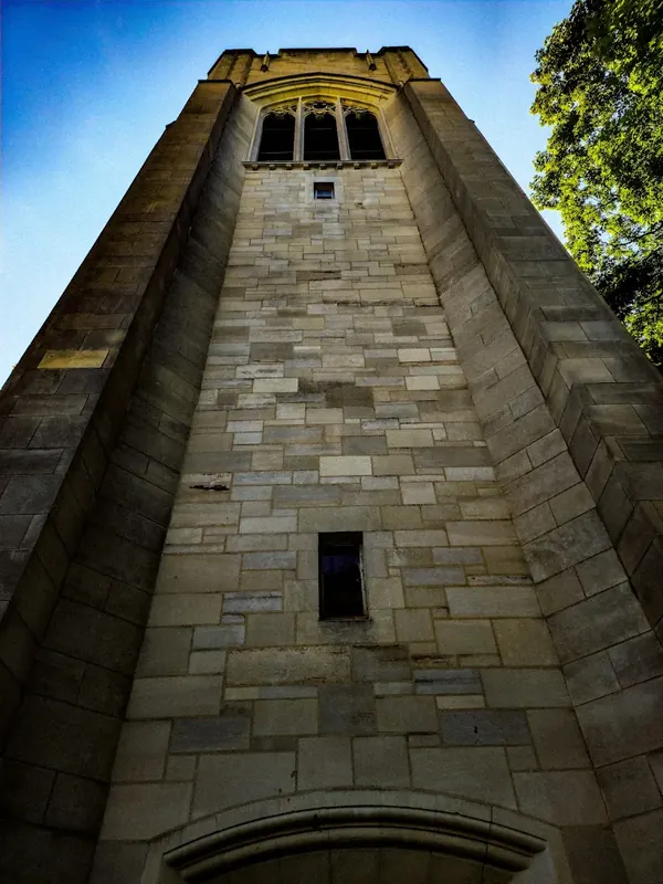 Stone Mariemont carillon tower seen from below against a blue sky