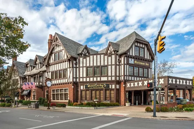 Tudor-style Mariemont Inn on a sunny day with blue sky and clouds