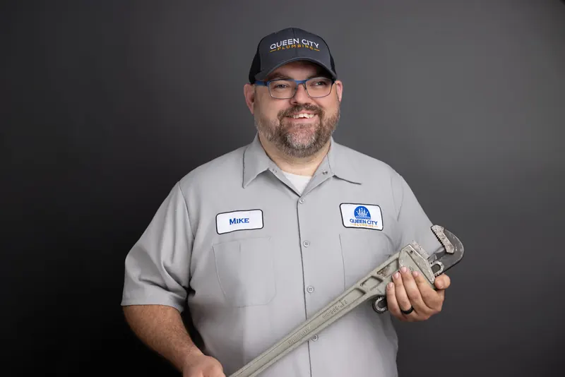 Mike Lipp, owner of Queen City Plumbing, holding a pipe wrench