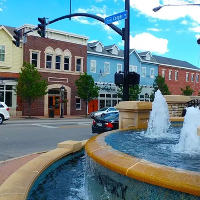 Fountain at the corner of Cooper Road with colorful brick and clapboard storefronts in Montgomery