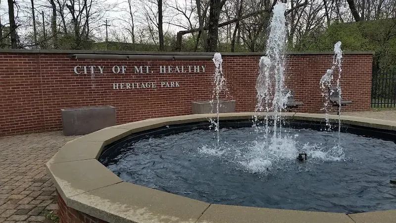 City of Mt. Healthy Heritage Park sign on a brick wall behind a round fountain