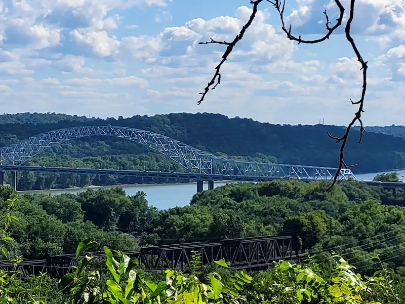 Arched highway bridge over the Ohio River seen from wooded hills near Cleves