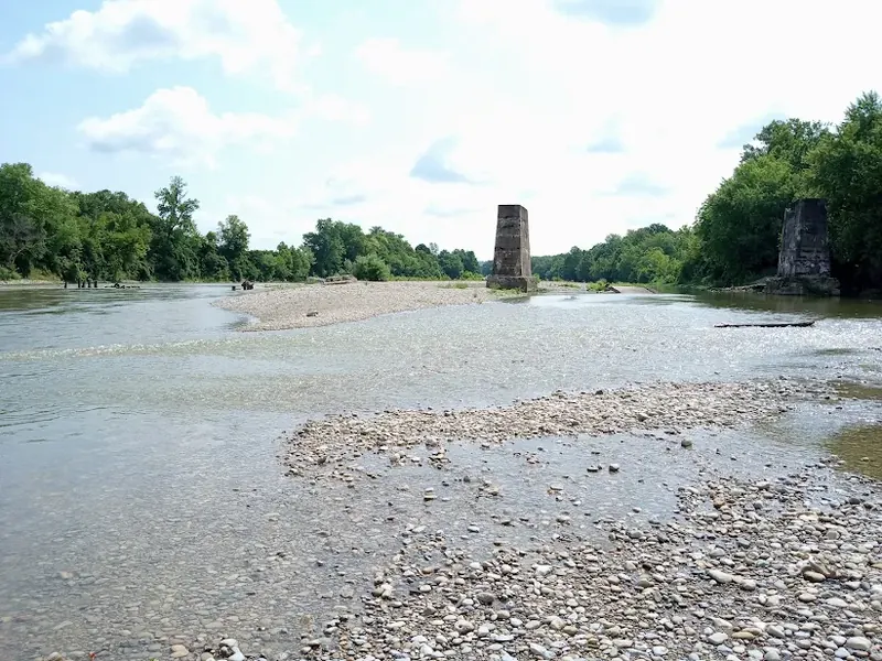 Old stone bridge piers standing in the shallow Great Miami River