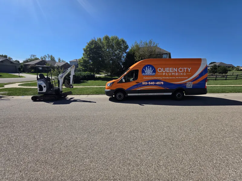Queen City Plumbing orange service van with the company logo and 513-540-4575 on the side wrap