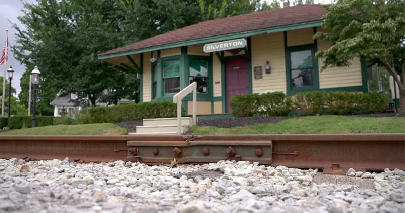 Small Silverton train depot with green trim beside the railroad tracks