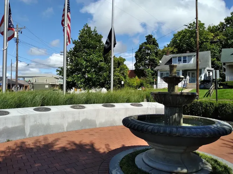 Veterans memorial with a tiered fountain and flags on a brick plaza in Silverton