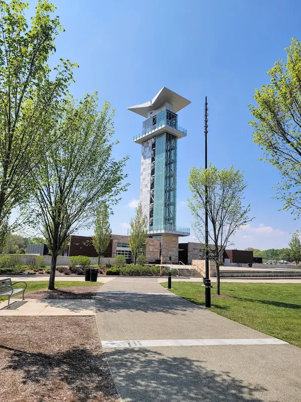 Summit Park observation tower in Blue Ash on a sunny day, seen from a tree-lined walkway