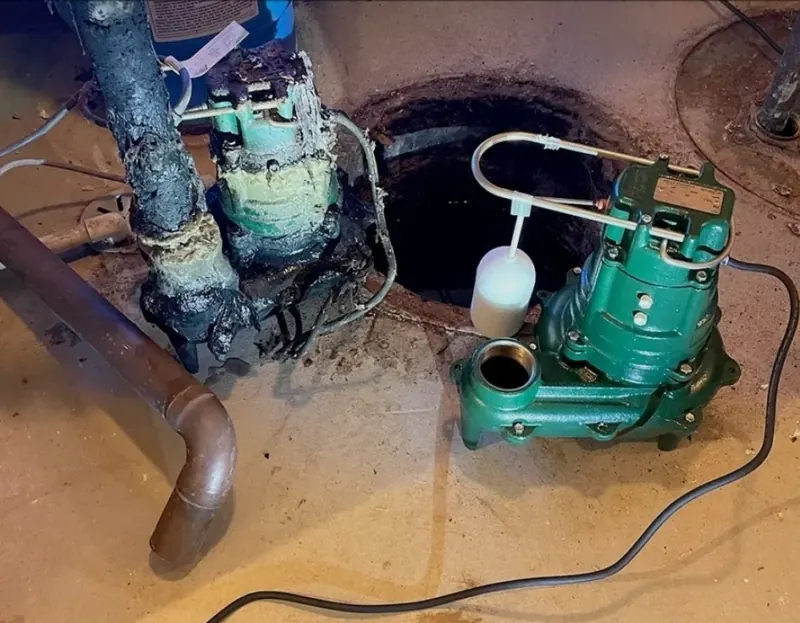 Old corroded pump pulled from a basement pit next to the new green replacement pump with its float switch