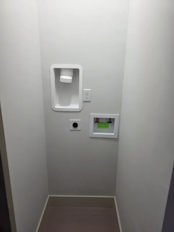 Recessed washing machine outlet box with hot and cold valves set in a new laundry room wall